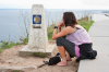 Kap Finisterre: Junge Frau  am Kilometerstein Null nimmt Abschied von ihrer Pilgerschaft