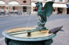 Basel: Eine Taube trinkt an einem Basiliskenbrunnen