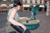 Basel: Eine Frau erfrischt sich an einem der vielen Basiliskenbrunnen Basels