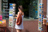 Basel: Eine junge Frau betrachtet Postkarten vor einem Buchladen