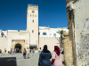 Flaneure auf der Place Chefchaouni auf ihrem Weg zum Uhrenturm und der Stadtmauer von Essaouira, Marokko